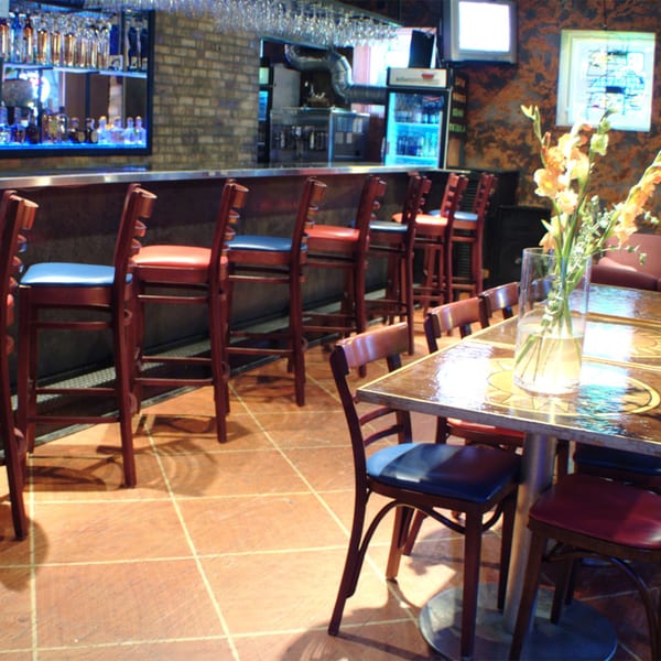 Interior of Cesar's Killer Margaritas, featuring a bar with stools and dining tables with chairs.